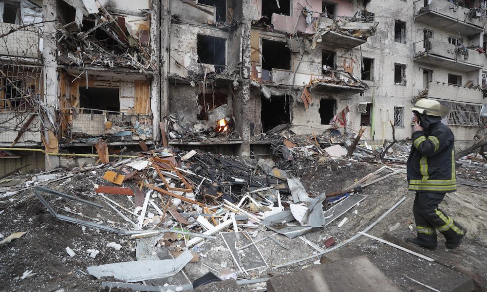 Un bomber observa un edifici de Kíev (Ucraïna) destrossat per les tropes russes / EFE